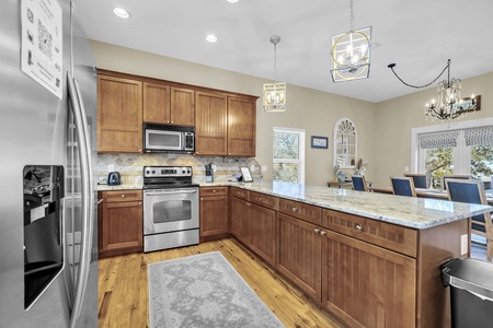 Step into your spacious gourmet kitchen with warm wood cabinetry, granite countertops, and stainless steel appliances—perfectly designed for gathering, cooking, and creating memories with loved ones.