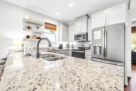 Your gourmet kitchen awaits with gleaming granite countertops, stainless steel appliances, and bright white cabinetry perfect for cooking memorable meals.