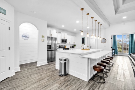 You'll love gathering around this stunning white kitchen island with stylish pendant lights and comfortable leather seating for six.