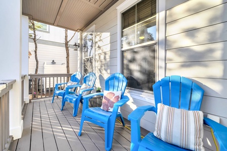 Unwind on your private covered porch with cheerful blue chairs perfect for morning coffee or evening relaxation.