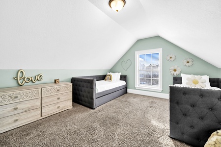 The loft bedroom with plush carpeting and plenty of space and light.