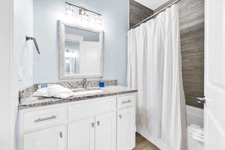 Your stylish bathroom features granite countertops, crisp white cabinetry, and a refreshing shower with modern tile work.