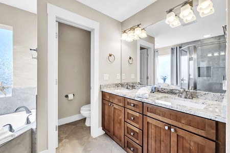 Indulge in your luxurious master bathroom featuring dual vanities with granite countertops, elegant lighting, and a private water closet for ultimate comfort.