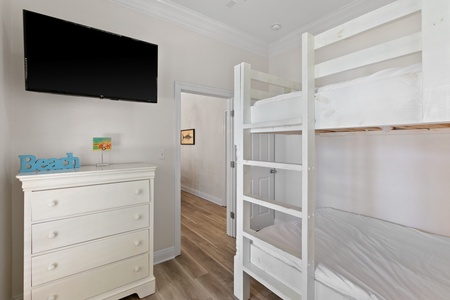 The ground floor bunk room features 2 full-size bunk beds and patio access!