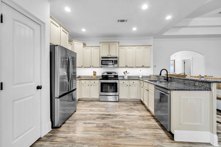 Your spacious kitchen features granite countertops, stainless steel appliances, and plenty of cabinet storage for preparing memorable meals during your stay.