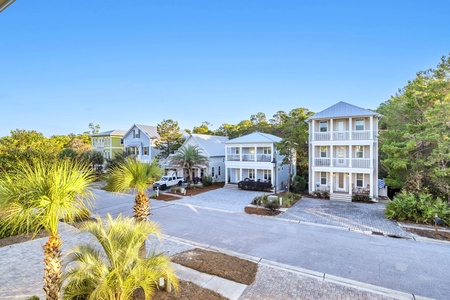 Coastal vacation rental community featuring modern beach houses with tropical landscaping and convenient parking.