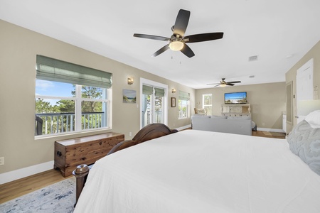 Sink into your plush bed beneath the gentle breeze of ceiling fans, while natural light and treetop views create a peaceful retreat where you'll truly unwind.