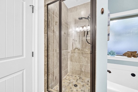 Step into your private shower sanctuary with elegant marble-look tiles and rainfall showerhead for a refreshing start to each day.