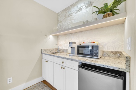 Refresh after a day of exploring—your kitchenette has everything you need, from a mini fridge to a microwave, with elegant granite counters and cheerful greenery above.
