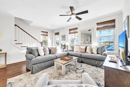 Sink into plush sectional seating where coastal breezes flow through bamboo blinds, creating your perfect retreat for relaxation.