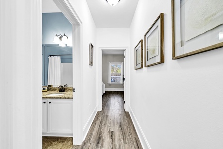 A bright hallways connects guest rooms and full bathroom.