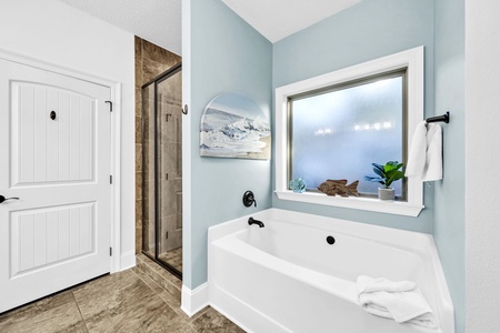 Unwind in your serene spa-like bathroom with a deep soaking tub and separate walk-in shower, perfect for relaxing after your adventures.