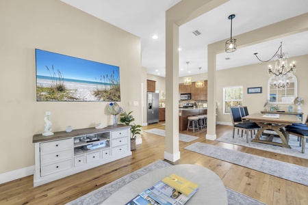 Step into your open-concept haven where soaring ceilings, warm hardwood floors, and beach-inspired decor create a light-filled space perfect for gathering with family and friends.