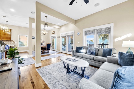 Sink into plush gray sofas in this airy living room, where warm wood floors and coastal blues create your perfect retreat.