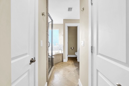Step into your private spa-like bathroom suite with sleek glass shower, soaking tub, and warm neutral tones creating the perfect relaxation retreat.