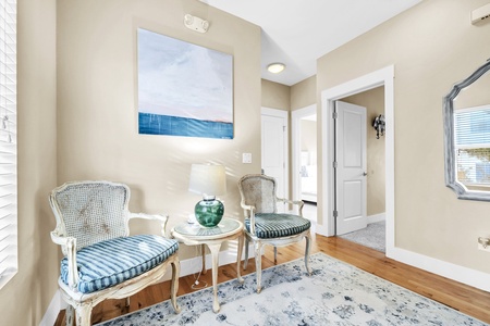 Unwind in this elegant seating nook where vintage charm meets coastal comfort. Striped chairs invite quiet moments with morning coffee.