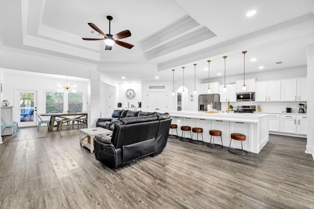 Relax in your spacious open-concept living area where comfort meets style with plush seating and a stunning kitchen island.