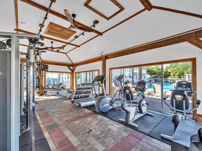 Stay fit with stunning pool views from this fully-equipped fitness center, featuring cardio machines, weights, and natural light streaming through expansive windows.