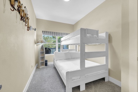 Fresh linens, soft carpeting, and cheerful bunk beds await. Rest easy in this cozy room—perfect for families or groups sharing fun-filled vacation days.