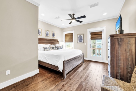 Drift off in your peaceful bedroom featuring rich wood furnishings, coastal artwork, and a private door to your balcony.