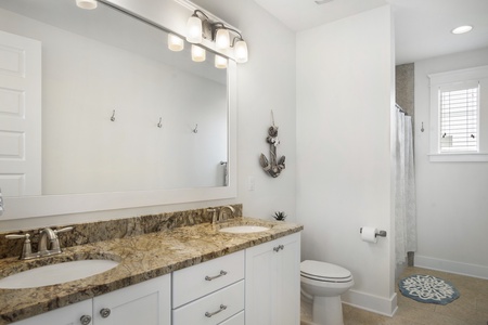 The hallway guest bath with dual vanities and full tub-shower combo!