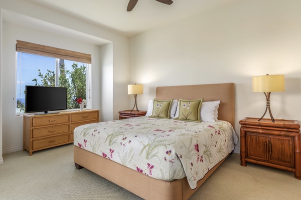 Primary bedroom with king sized bed, flat screen TV, and ocean views.