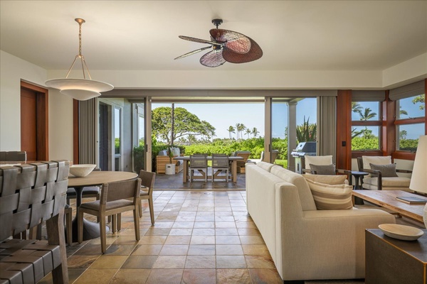 Open concept great room w/dining table, living area, and sliding glass doors to the lanai.