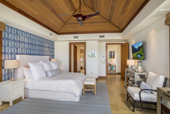 Reverse view of the primary bedroom with vaulted ceilings, wall-mounted television & walk-in closet