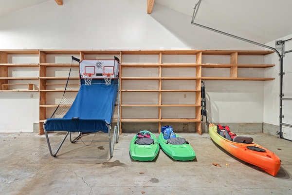 large 2-car garage with a hobby room and carport, a Peloton bike, 1 adult and 2 kids kayaks, and a ping pong table for added entertainment and enjoyment.