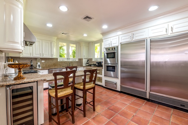 Prepare meals in the spacious gourmet kitchen, featuring modern appliances and a cozy breakfast nook.