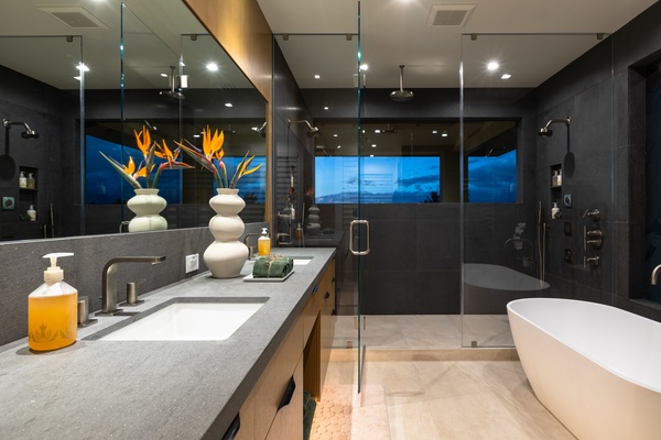 The primary ensuite bath with a large soaking tub and separate shower with natural lighting.