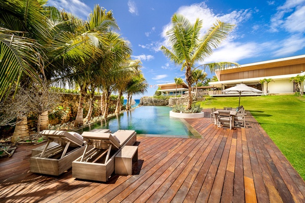 Elegant poolside deck, with stylish lounge chairs and shaded seating areas.