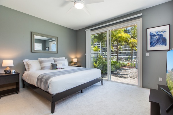 First-floor primary bedroom with en suite bathroom and sliding door that leads to the back yard.