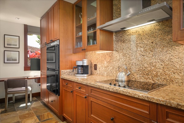 Built-in electric range, double oven, and elegant cabinetry with top tier dishware.