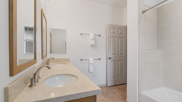 The ensuite bathroom has a shower/tub combo and dual vanities.