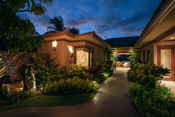 Front entryway at twilight with tiki torches lit.