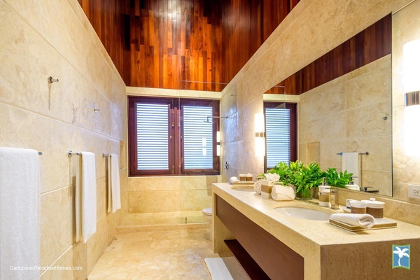 Full ensuite bathroom with a sleek design and large mirror.