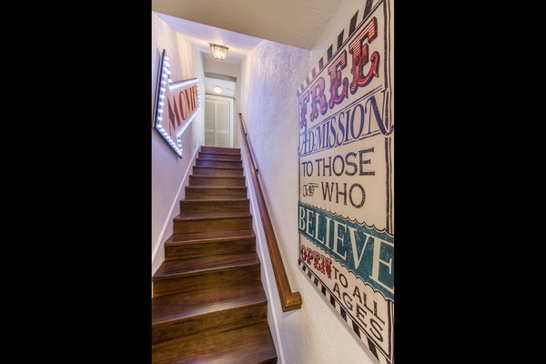 Stairway down to the lower level, where you will find the media room, two bedrooms and a half kitchen