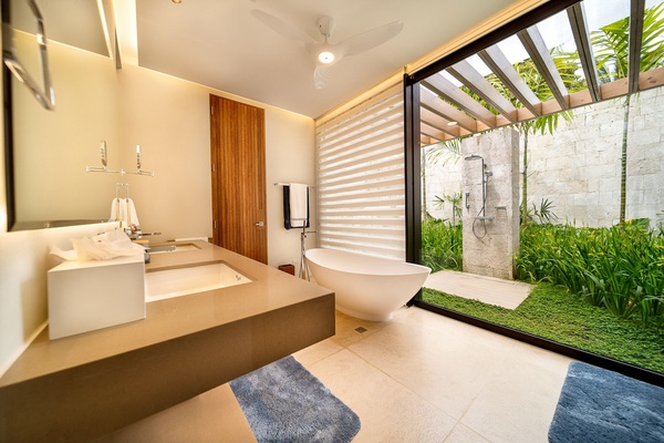 Spa-like modern ensuite bathroom, with a freestanding tub, sleek vanity, and an outdoor shower.