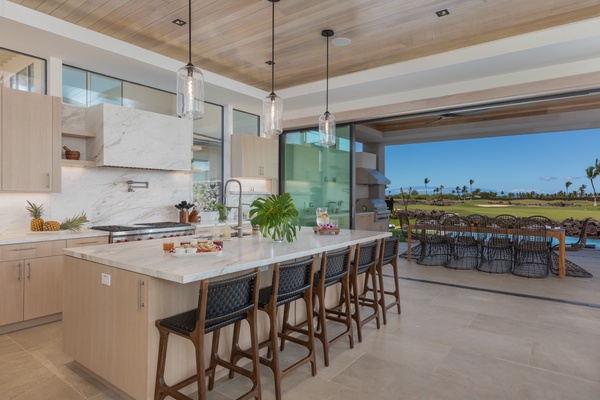 This beautifully designed kitchen features a large central island with stylish bar stools, providing the perfect spot for morning coffee or casual dining.