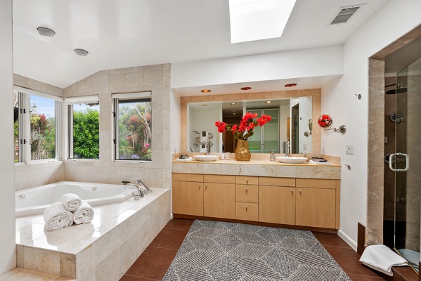 Primary bathroom with double vanities, corner jetted tub, shower and closets