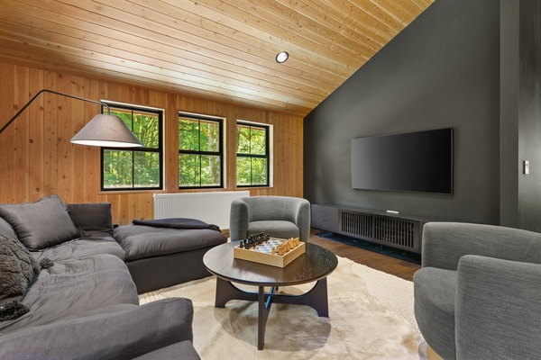 Lounge in the media room that has a reading light and a chess board, a classic game inviting strategy and leisure in equal measure.