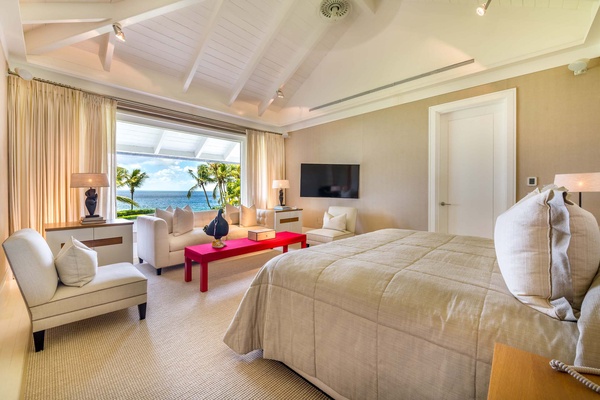 Retreat to the primary bedroom, featuring a king bed with expansive windows framing breathtaking ocean views.