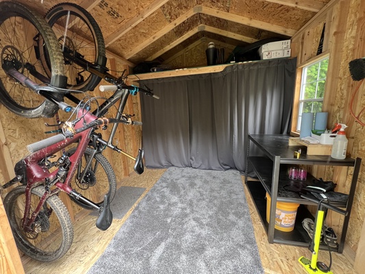 Organized shed with storage space for bikes and outdoor gear.