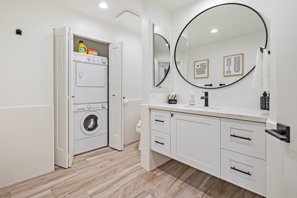 This bright bathroom includes a convenient stacked washer and dryer tucked behind folding doors, allowing you to keep up with laundry during your stay.