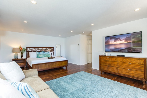 Downstairs primary with cable TV, couch, and king bed.