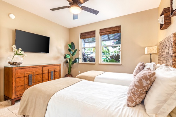 Guest bedroom with two twin beds (can convert to a king upon request), wall mounted smart flat screen TV and an adjacent full bath.