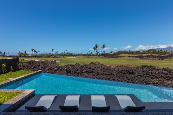 Enjoy a refreshing dip in the pool with a serene golf course view, perfect for a sunny afternoon.