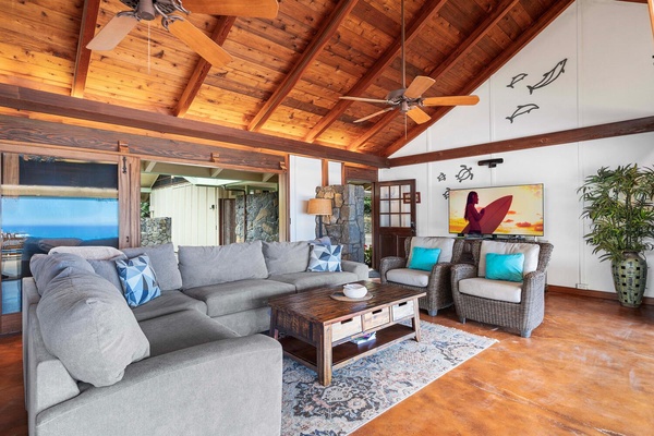 The great room features plush sectional seating and high, vaulted ceiling.