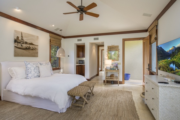 Alternate view leading into the kitchenette & en suite bath, showcasing the private entrance, vaulted ceilings, & television